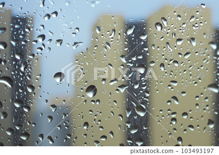 Rain. Raindrops on the window. Rainy day. Blue tone. Drops of water on the glass. Macro shooting. Texture. Concept of autumn weather, background of drops of water rain on glass transparent. 103493197