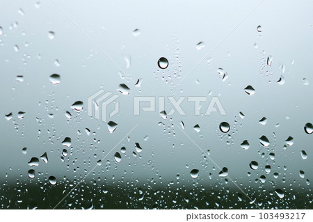 Rain. Raindrops on the window. Rainy day. Blue tone. Drops of water on the glass. Macro shooting. Texture. Concept of autumn weather, background of drops of water rain on glass transparent. Rain. Raindrops on the window. Rainy day. Blue tone. Drops of water on the glass. Macro shooting. Texture. Concept of autumn weather, background of drops of water rain on glass transparent. 103493217