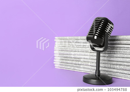 Newspapers and vintage microphone on light violet background, space for text. Journalist's work Newspapers and vintage microphone on light violet background, space for text. Journalist's work 103494788