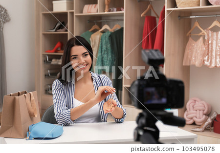 Fashion blogger recording new video at table indoors 103495078