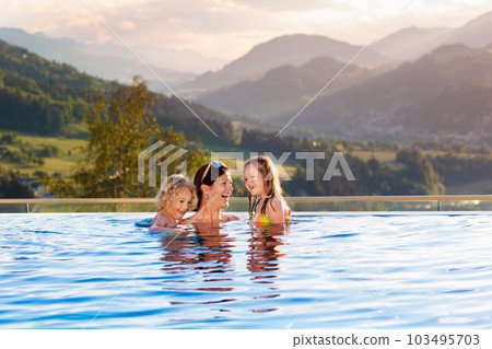 Family in swimming pool with mountain view 103495703