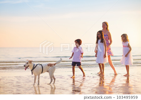 Family walking on tropical beach at sunset Family walking on tropical beach at sunset 103495959