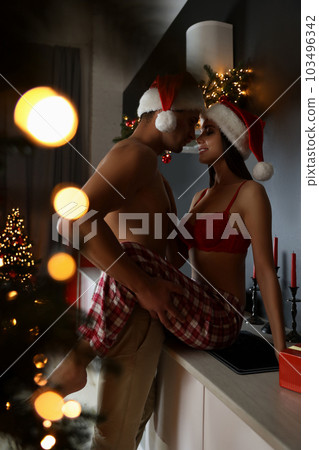 Passionate young couple enjoying each other at home. Christmas celebration Passionate young couple enjoying each other at home. Christmas celebration 103496342