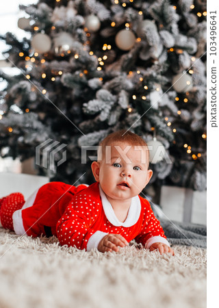 Baby on the background of a Christmas tree Baby on the background of a Christmas tree 103496641