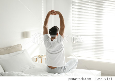 Man awakening on bed at home. Lazy morning 103497151