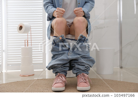 Woman suffering from hemorrhoid on toilet bowl in rest room, closeup 103497166