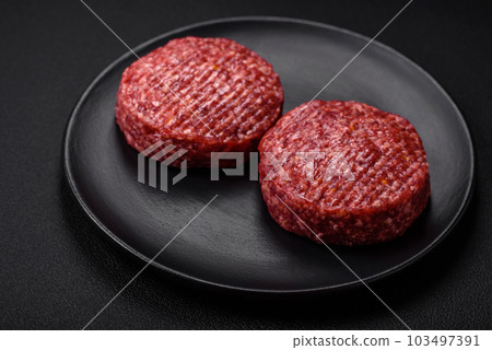 Fresh raw ground beef burger patty with salt and spices 103497391