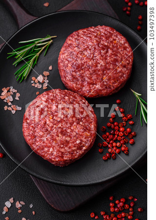 Fresh raw ground beef burger patty with salt and spices 103497398