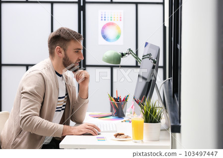 Male designer working at desk in office Male designer working at desk in office 103497447