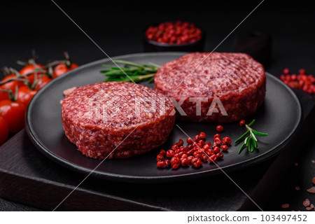 Fresh raw ground beef burger patty with salt and spices 103497452