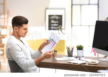 Male designer working at desk in office Male designer working at desk in office 103497453
