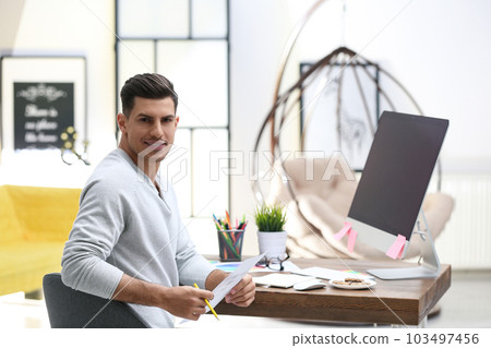 Male designer working at desk in office 103497456