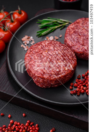 Fresh raw ground beef burger patty with salt and spices 103497459