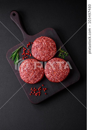 Fresh raw ground beef burger patty with salt and spices 103497480