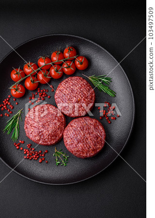 Fresh raw ground beef burger patty with salt and spices 103497509