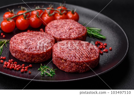 Fresh raw ground beef burger patty with salt and spices 103497510