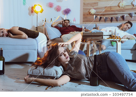 Group of friends in messy room after party Group of friends in messy room after party 103497754