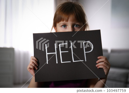 Abused little girl with sign HELP indoors. Domestic violence concept 103497759