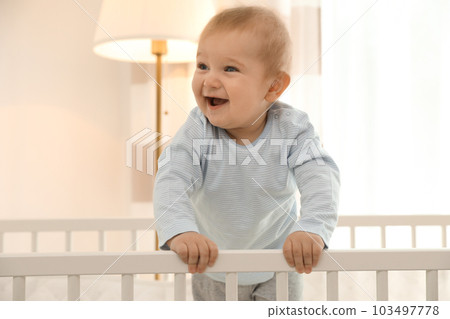 Cute little baby in crib at home 103497778