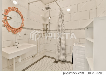 a bathroom with white tile and black and white tiles on the walls there is a sink, toilet, mirror and shower 103498203