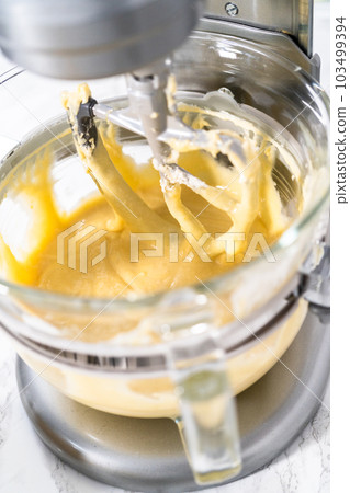 Mixing ingredients into the batter for lemon pound cake. Mixing ingredients into the batter for lemon pound cake. 103499394