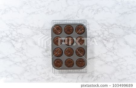Flat lay. Cooling freshly baked chocolate peppermint cupcakes on a kitchen counter. 103499689
