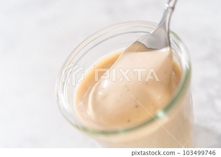 Homemade Swedish meatball sauce in a glass jar on a kitchen counter. 103499746