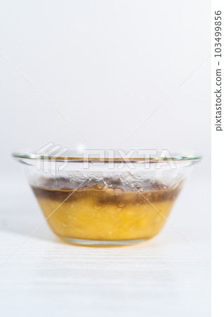 Mashed overripe banana in a glass mixing bowl. 103499856