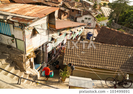 The back view of a man who brings his luggage into the old town (Kampong) of Jagjakarta 103499891