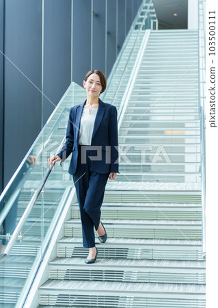 Businesswoman moving up the stairs Businesswoman moving up the stairs 103500111