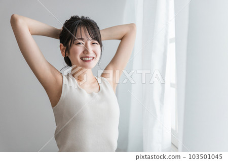 A woman who stretches in front of the curtain when waking up and waking up (serotonin, refreshment, flexibility exercises) A woman who stretches in front of the curtain when waking up and waking up (serotonin, refreshment, flexibility exercises) 103501045