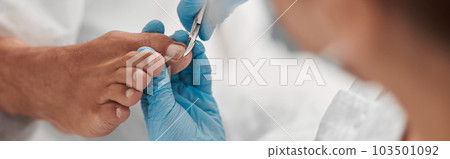 Pedicure master in gloves cuts toenail of male client in beauty salon 103501092