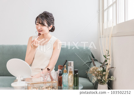 A woman who uses a make-up brush at home to make up the chin, such as shading, shadowing, and highlighting A woman who uses a make-up brush at home to make up the chin, such as shading, shadowing, and highlighting 103502252