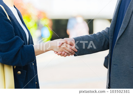 Men and women shaking hands in the city Welcome Partnership 103502381