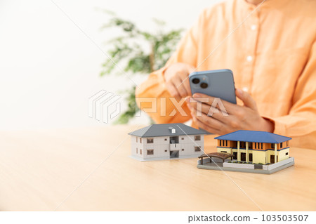 操作智能手機和房子的資深婦女 103503507