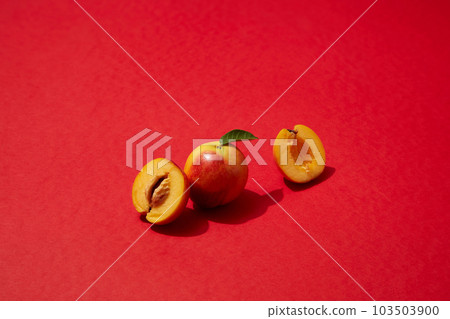 A peach and a peach cut in half are displayed on red plane. Peach (Prunus persica) may help keep your peepers healthy thanks to an antioxidant in peaches 103503900