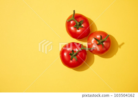 Three fresh tomatoes decorated on a light yellow background. Tomato (Solanum lycopersicum) is packed with vitamins and nutrients that are so advantageous for the skin Three fresh tomatoes decorated on a light yellow background. Tomato (Solanum lycopersicum) is packed with vitamins and nutrients that are so advantageous for the skin 103504162