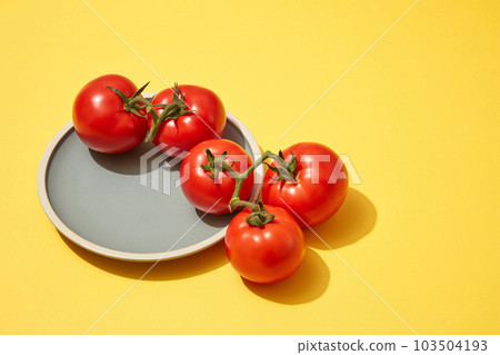 A dish of tomatoes with a blank space to display your product that extracted from Tomato (Solanum lycopersicum). Copy space in the right side for text adding 103504193