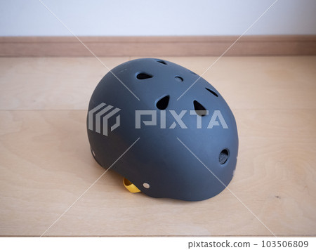 Black helmet for action sports such as BMX placed on wooden flooring 103506809