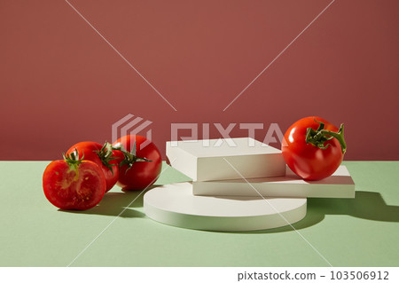 Front view of fresh tomatoes decorated with white podiums on a pink background. Minimal scene with copy space for cosmetics, business branding and product presentation 103506912