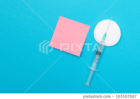 Vaccination or Revaccination Concept - A Medical Syringe on Blue Table Vaccination or Revaccination Concept - A Medical Syringe on Blue Table 103507087