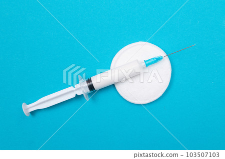 Vaccination or Revaccination Concept - A Medical Syringe on Blue Table Vaccination or Revaccination Concept - A Medical Syringe on Blue Table 103507103