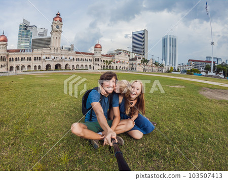 happy family makes selfie on the background on background of Merdeka square and Sultan Abdul Samad Building. Traveling with children concept happy family makes selfie on the background on background of Merdeka square and Sultan Abdul Samad Building. Traveling with children concept 103507413