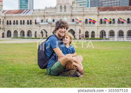 Dad and son on background of Merdeka square and Sultan Abdul Samad Building. Traveling with children concept Dad and son on background of Merdeka square and Sultan Abdul Samad Building. Traveling with children concept 103507510