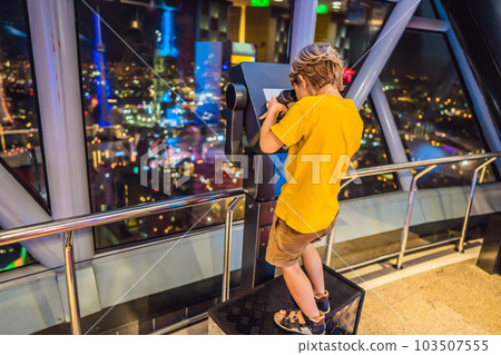 Little boy looks at Kuala lumpur cityscape. Panoramic view of Kuala Lumpur city skyline evening at sunset skyscrapers building in Malaysia. Traveling with kids concept Little boy looks at Kuala lumpur cityscape. Panoramic view of Kuala Lumpur city skyline evening at sunset skyscrapers building in Malaysia. Traveling with kids concept 103507555