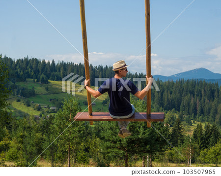 man traveler enjoying of swinging on heavenly swing and mountain view 103507965