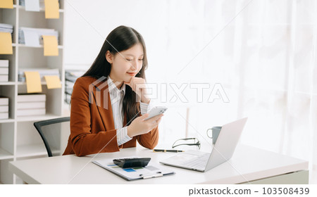 Asian businesswoman working in the office with working notepad, tablet and laptop documents in office 103508439