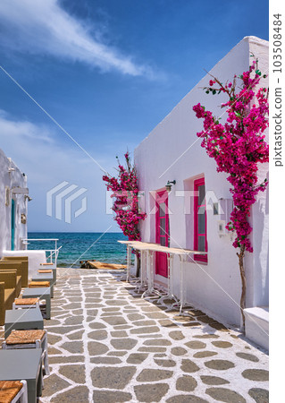 Beautiful alleyway of Greek island towns open to seafront on sunny day 103508484