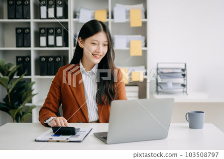 Asian businesswoman working in the office with working notepad, tablet and laptop documents in office Asian businesswoman working in the office with working notepad, tablet and laptop documents in office 103508797