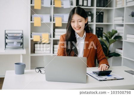 Asian businesswoman working in the office with working notepad, tablet and laptop documents in office Asian businesswoman working in the office with working notepad, tablet and laptop documents in office 103508798
